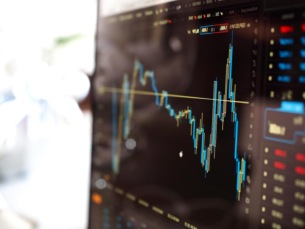 Economic analyst reviewing regional data charts and market reports at a desk